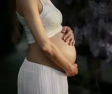 schwangere Frau vor busch
