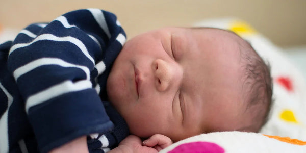 Baby mit gestreiftem Shirt schläft 
