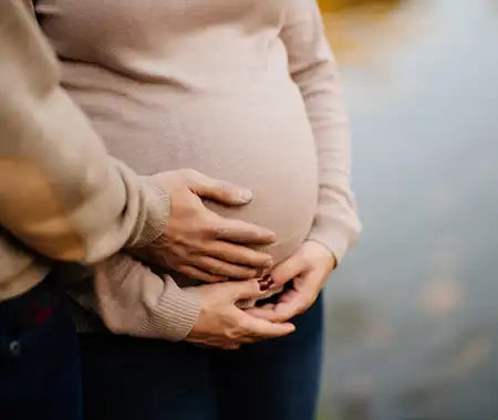 Schwangere Frau mit Händen auf ihrem Bauch