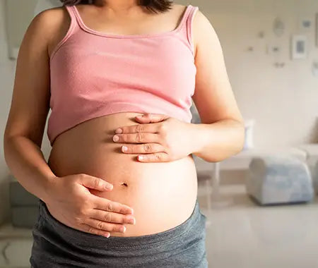 schwanger Frau mit ihren Händen auf dem Bauch