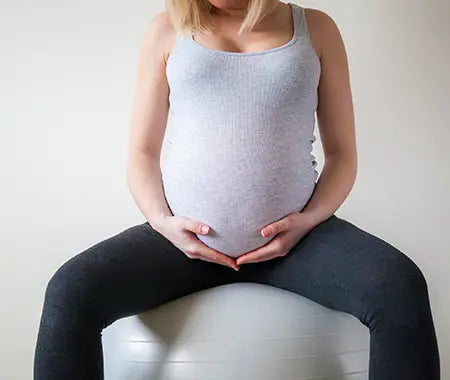 schwangere Frau auf Gymnastikball